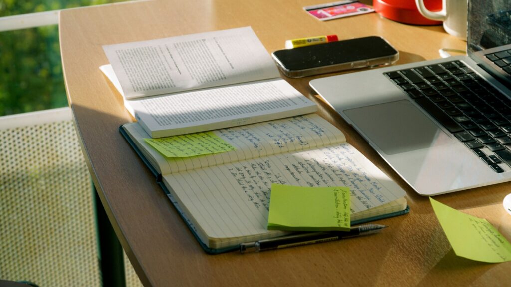 Cuaderno con planificación de estudio, apuntes y portátil durante la preparación de oposiciones a Guardia Civil