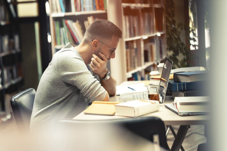 Aspirante a Guardia Civil estudiando concentrado en una biblioteca durante la preparación de oposiciones